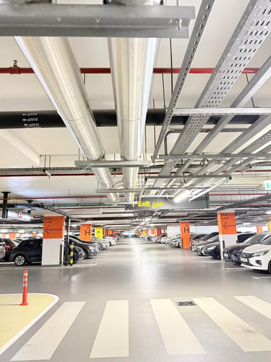 Insulated chilled water piping routed through a shopping mall car park